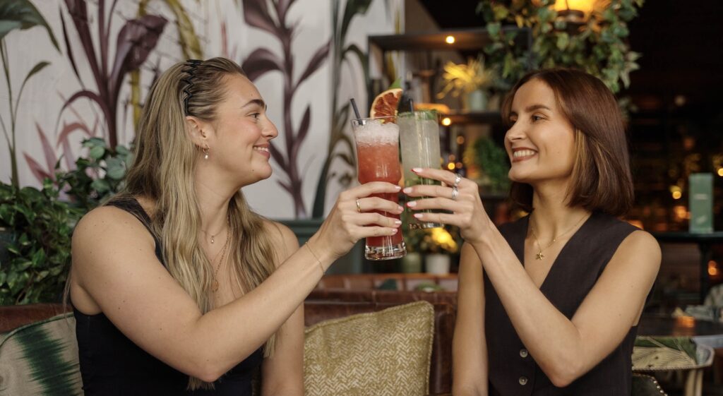 Two people enjoying cocktails at The Botanist